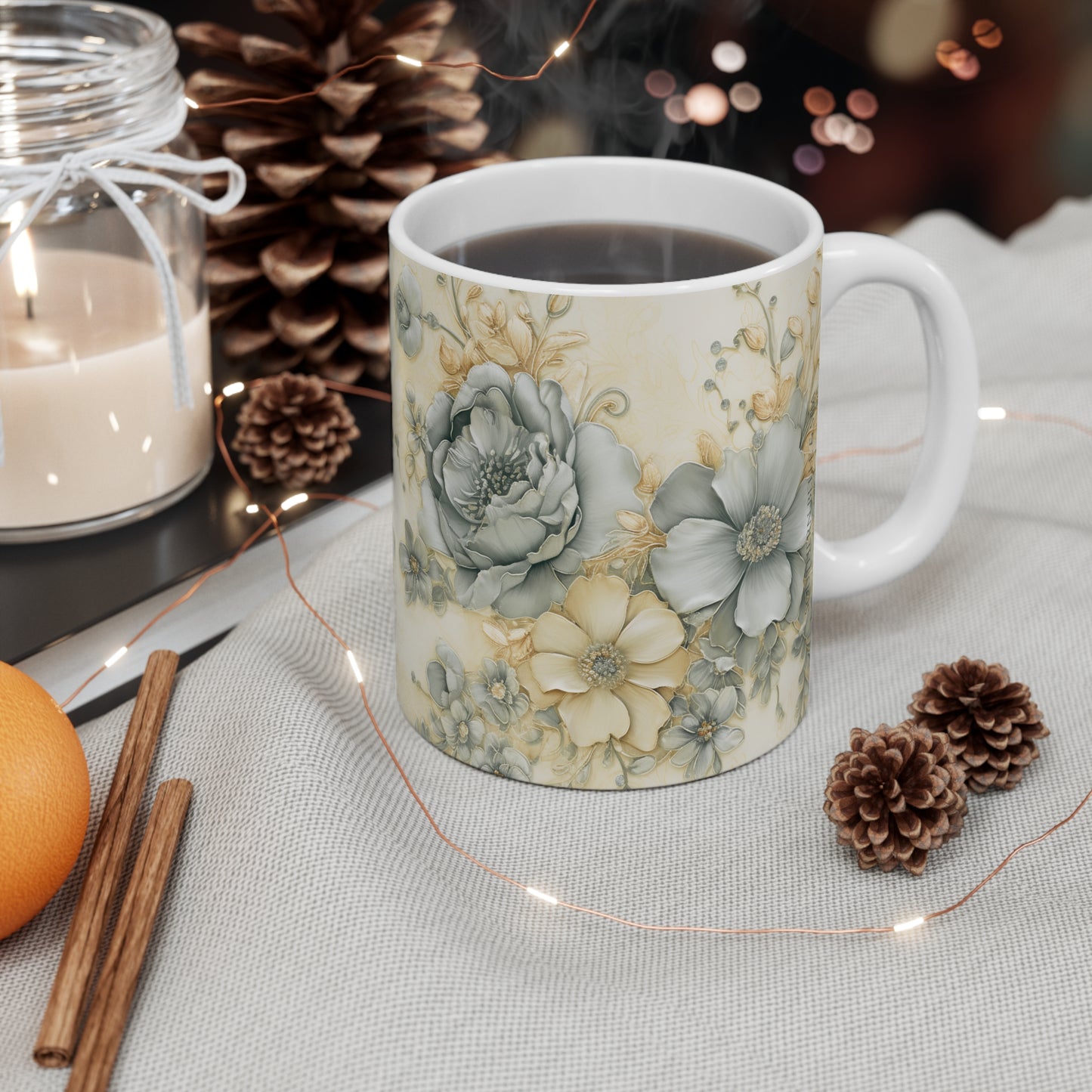 Floral-patterned mug on a table with decorative elements like candles and pinecones.