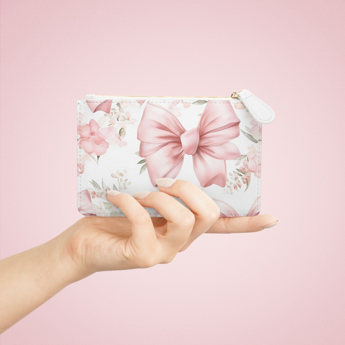 Hand holding a floral pouch with pink bows against a pink background