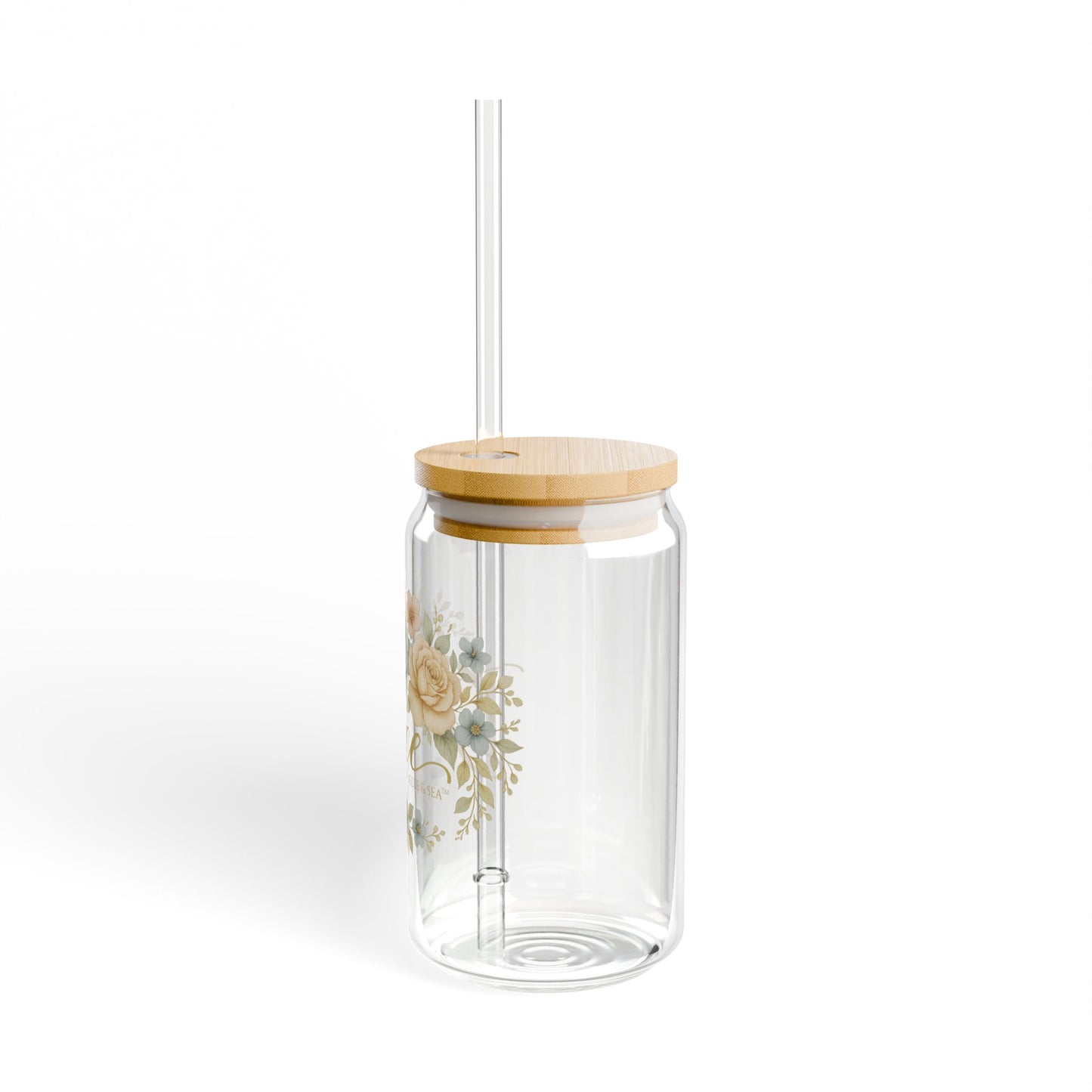 Clear glass tumbler with wooden lid and floral design on a white background