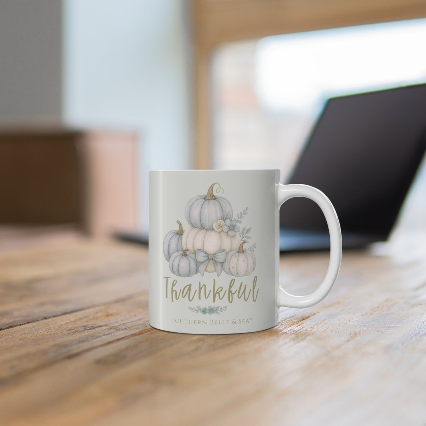 Mug with pumpkin design and 'Thankful' text on a wooden surface