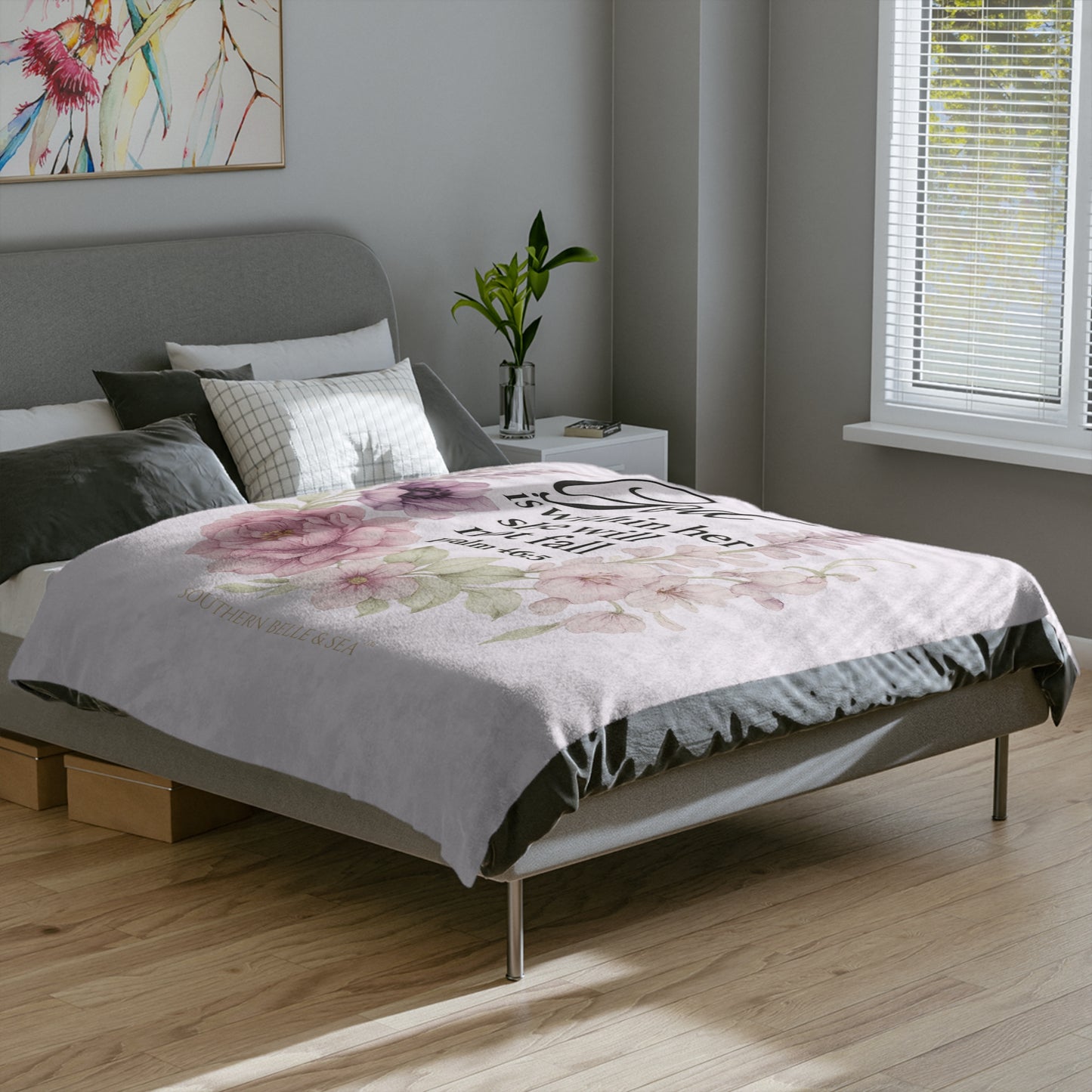 Bedroom with a bed featuring a floral comforter and a painting on the wall.