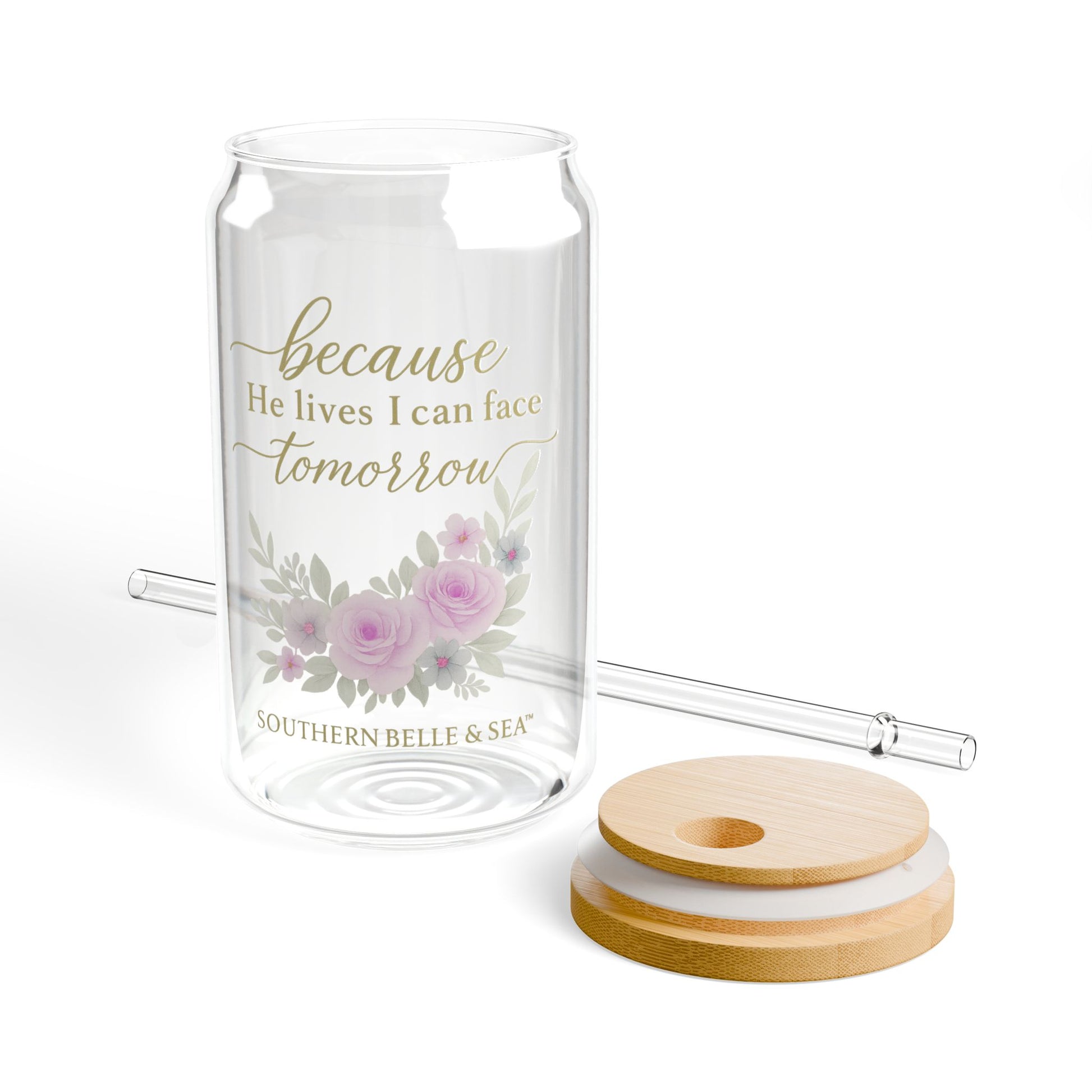 Glass tumbler with floral design and text, including a straw and coasters on a white background.