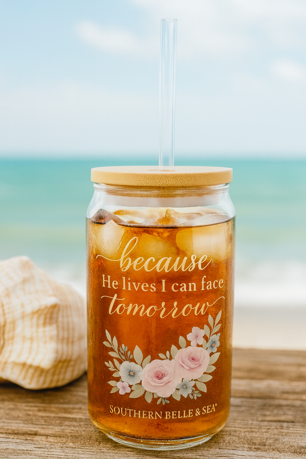 Glass tumbler with floral design and text on a beach setting