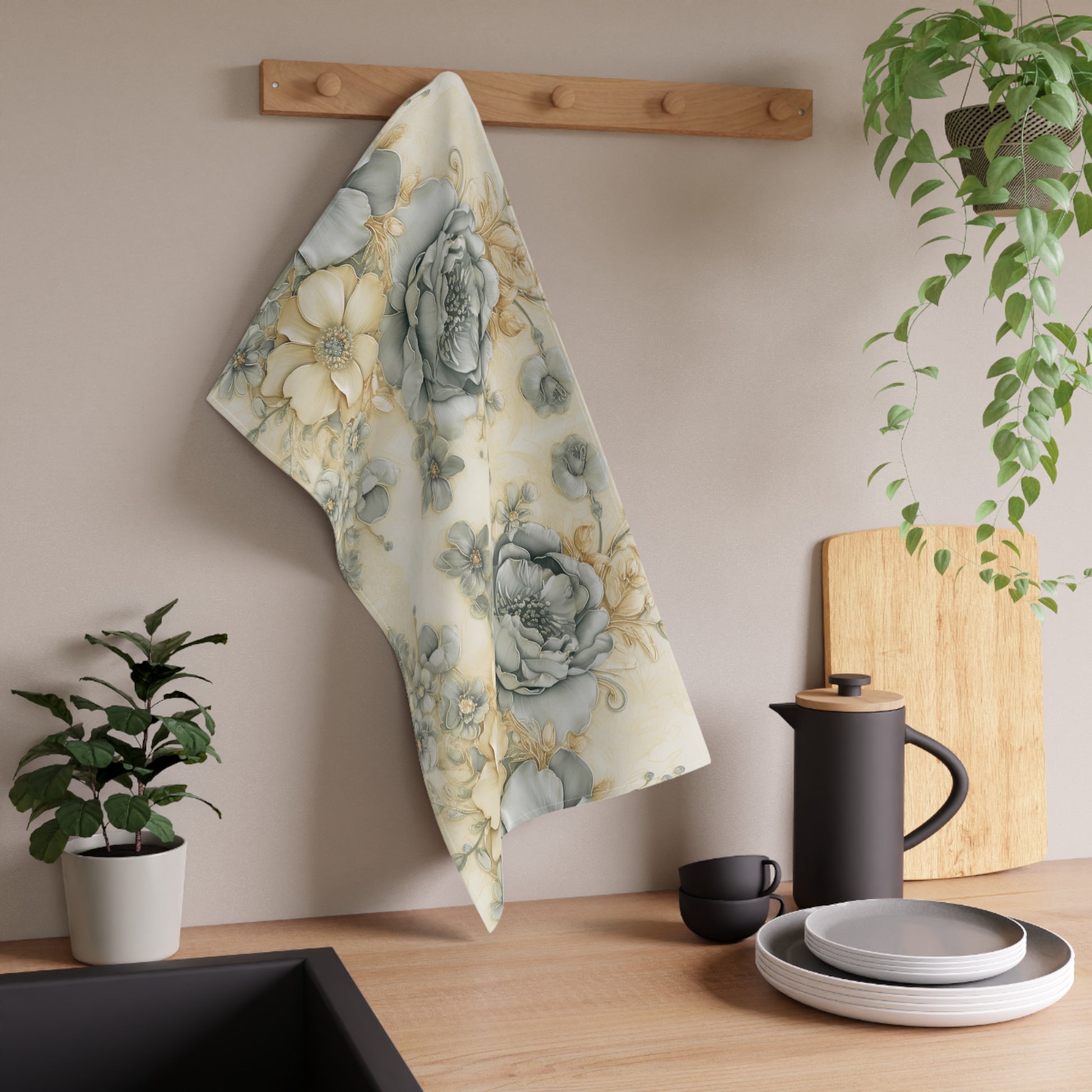Floral towel hanging on a wooden rack with kitchen items and plants in the background