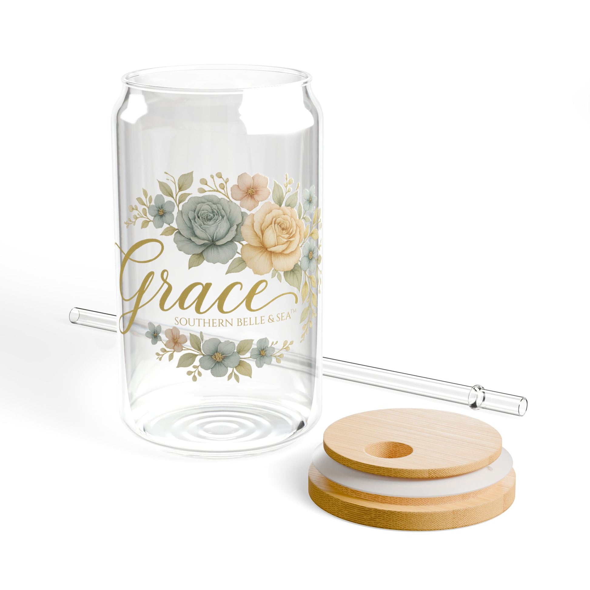 Glass tumbler with floral design, straw, and coasters on a white background