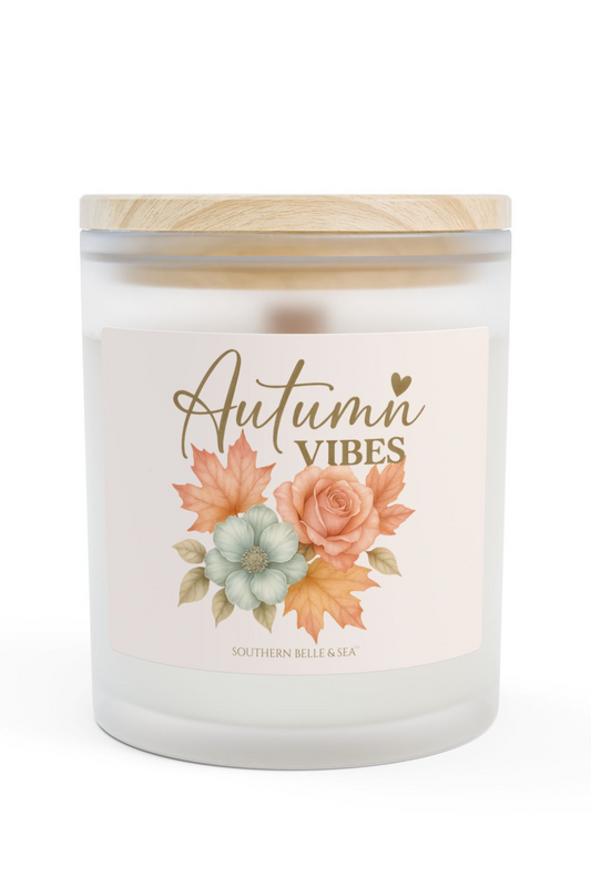 Candle with 'Autumn Vibes' label featuring floral design on a white background