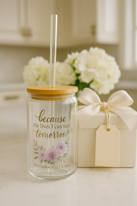 Glass tumbler with straw and wooden lid on a kitchen counter with flowers and a gift box in the background.