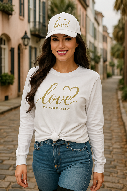 Woman wearing a white sweatshirt with 'love' printed on it, standing on a cobblestone street.