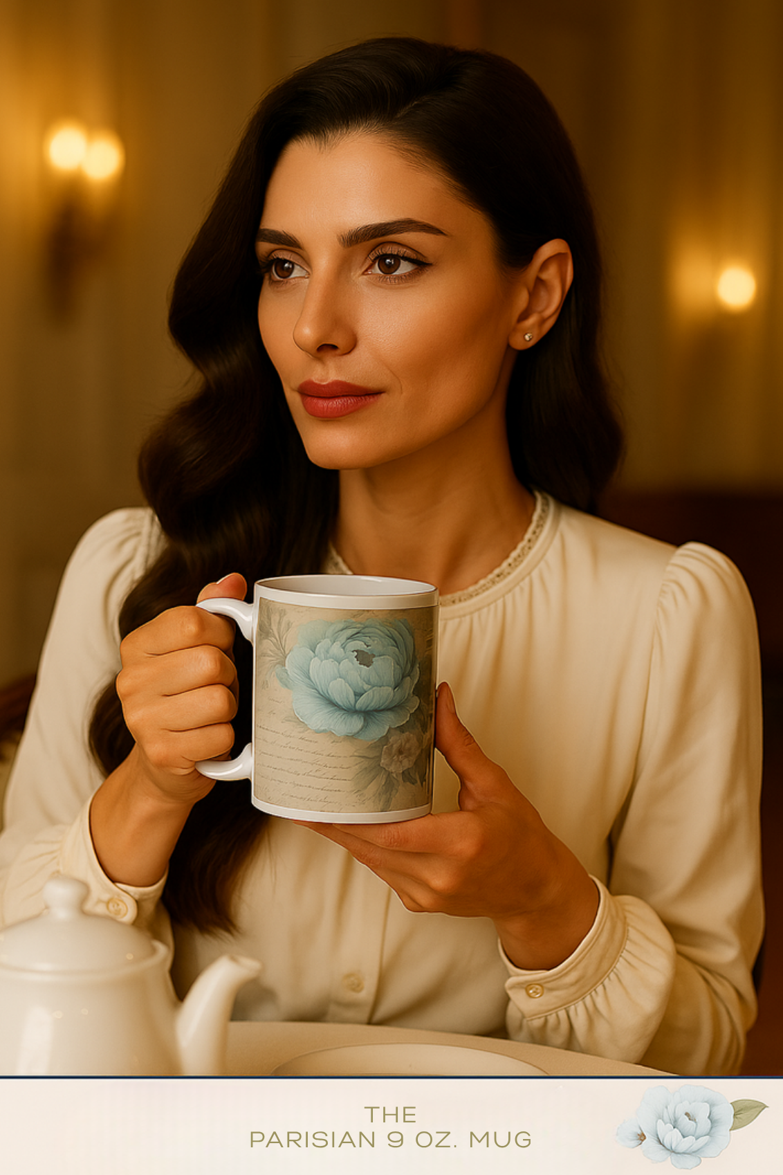 Woman in cream blouse holding The Parisian 9 oz. Mug with blue peony illustration.