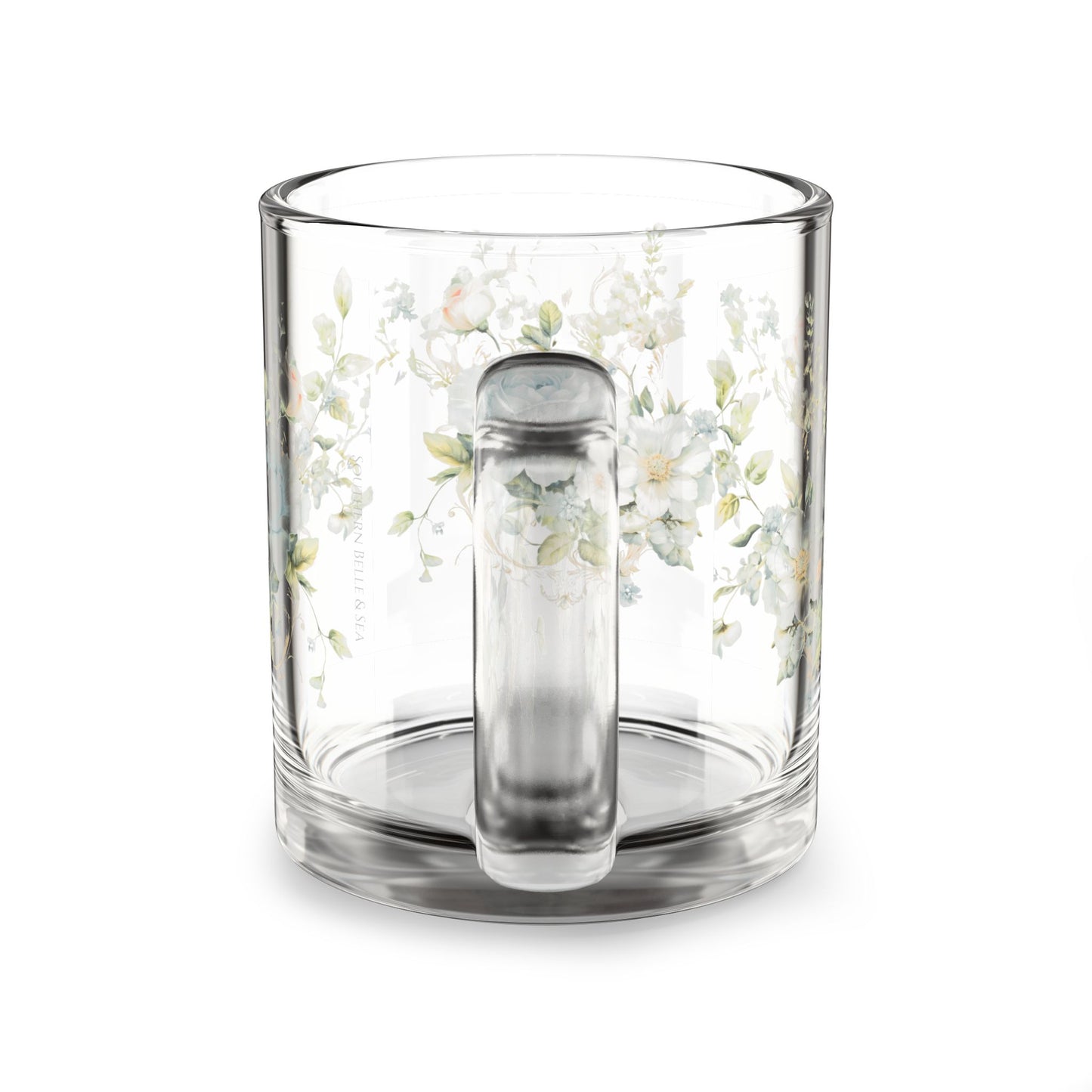 Clear glass mug with floral design and handle on a white background
