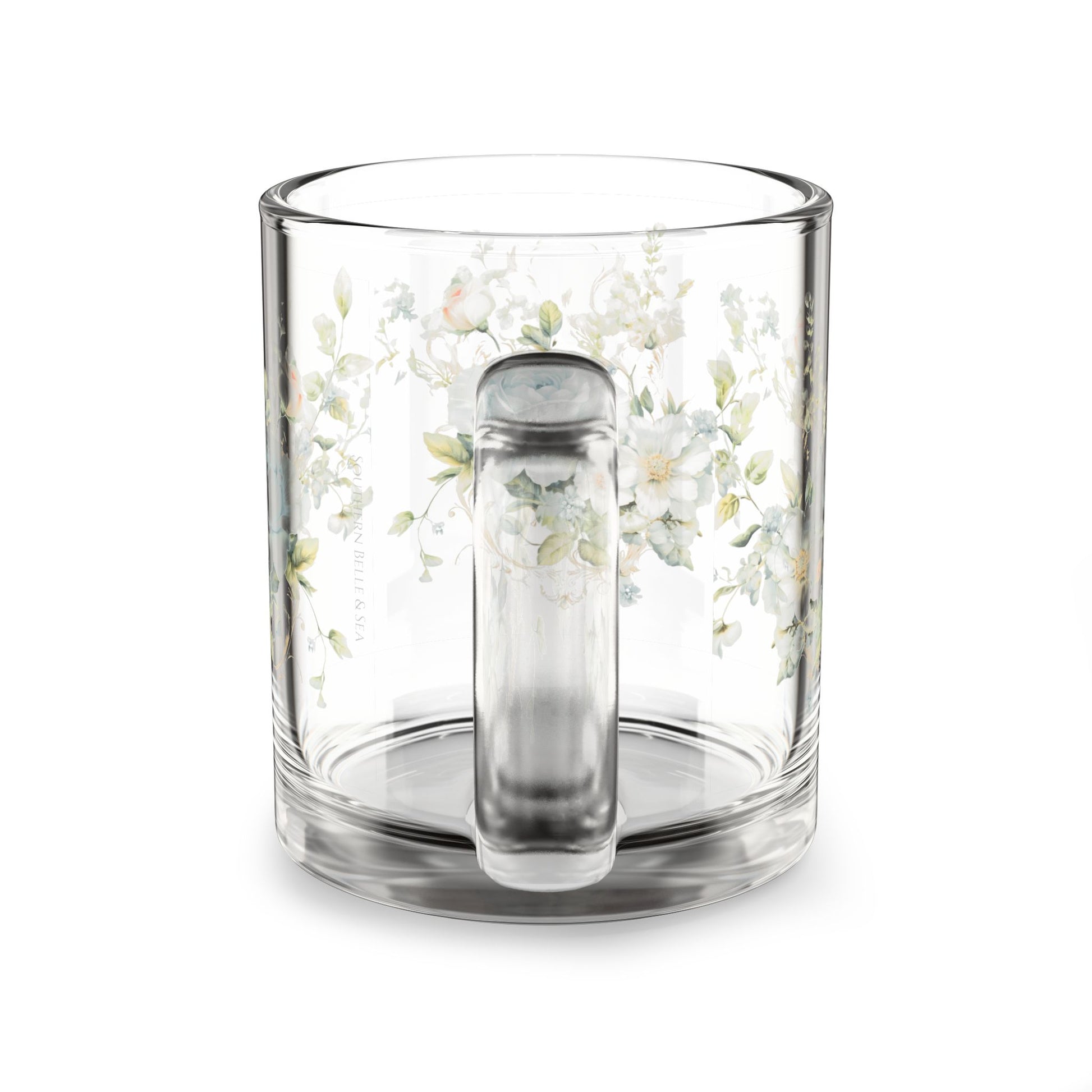 Clear glass mug with floral design and handle on a white background