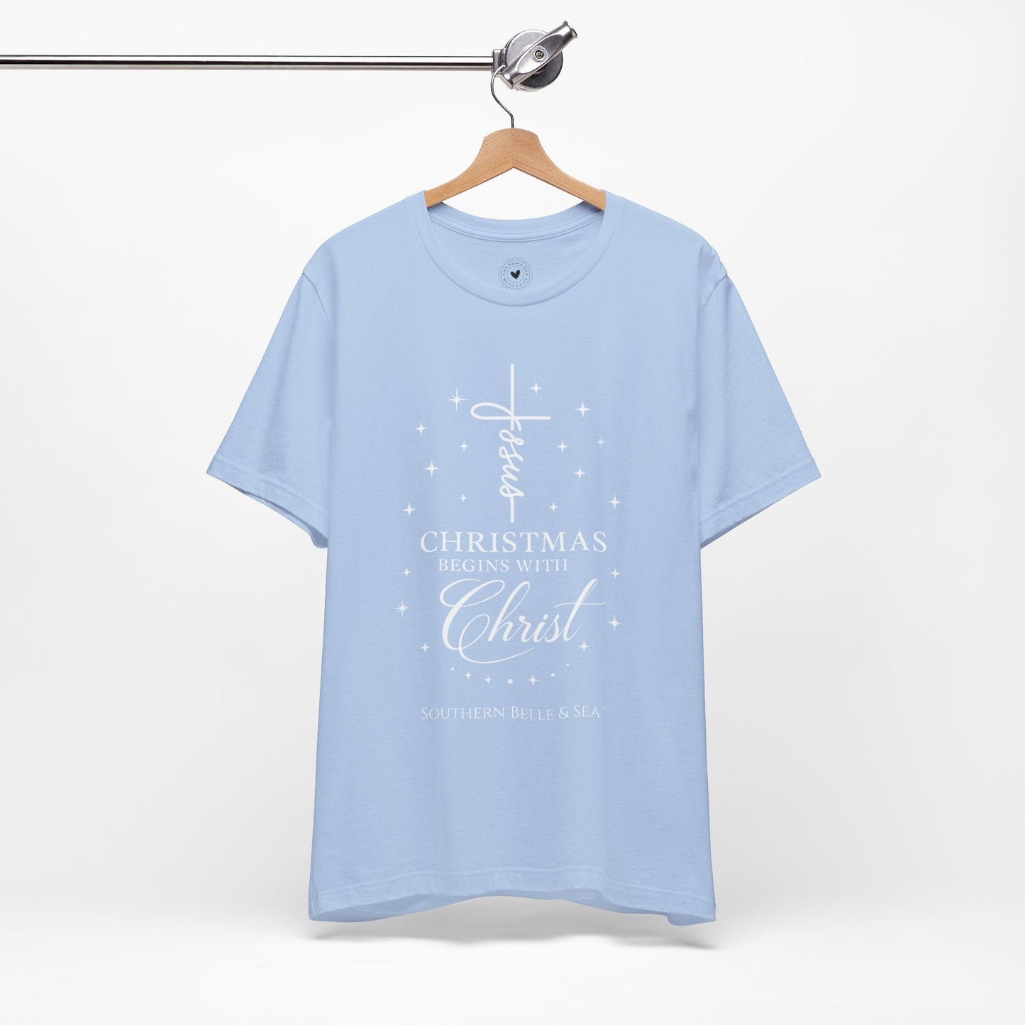 Front view of “Christmas Begins with Christ” shirt showing vertical Jesus cross and stars
