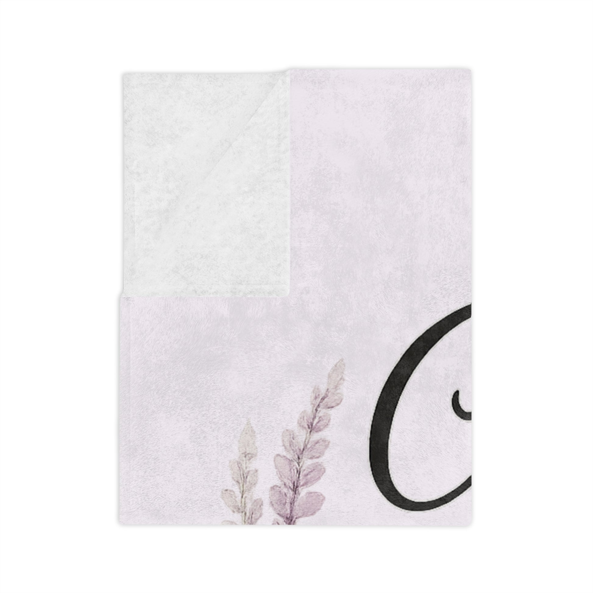 White towel with floral design and black circular logo on a white background