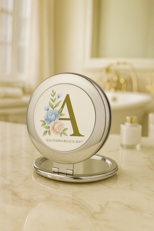 Compact mirror with floral design and 'A' on a bathroom counter